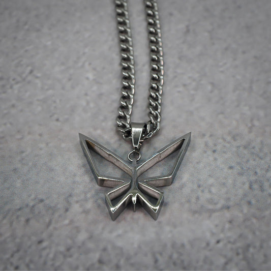 Silver butterfly pendant necklace on a grey counter.