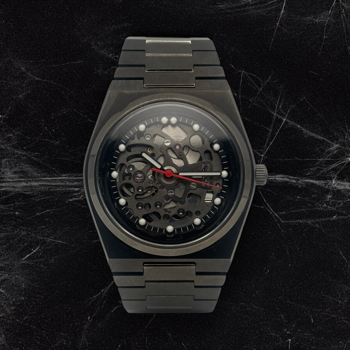 Luxury black watch with mechanical components on a dark marble background