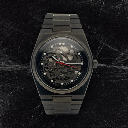 Luxury black watch with mechanical components on a dark marble background