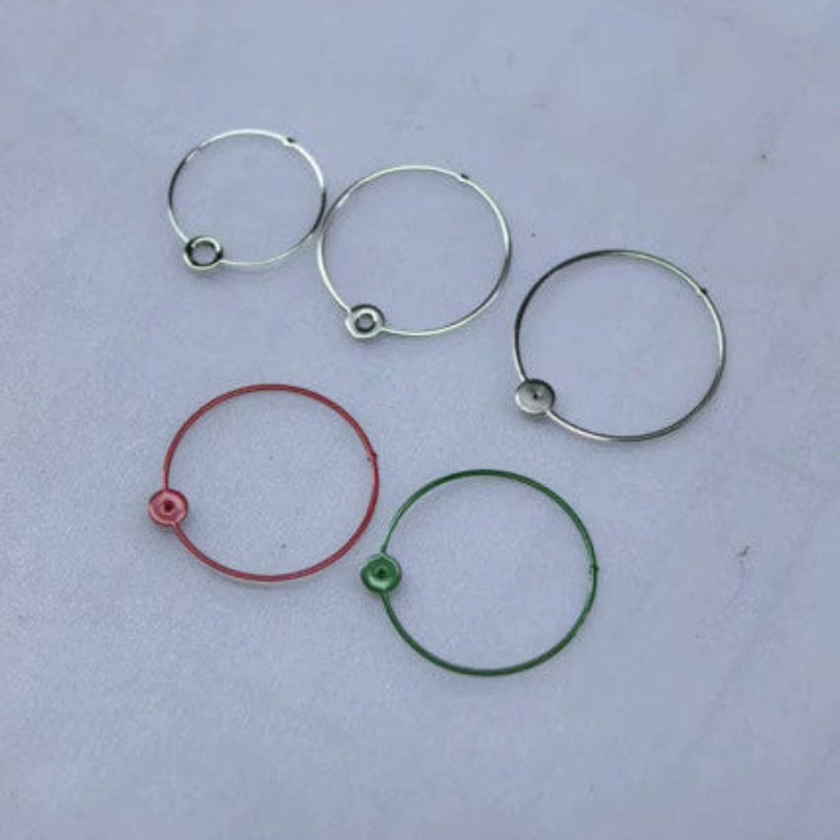 A set of circular watch hands, made from polished silver, shown in red, green and silver colour options