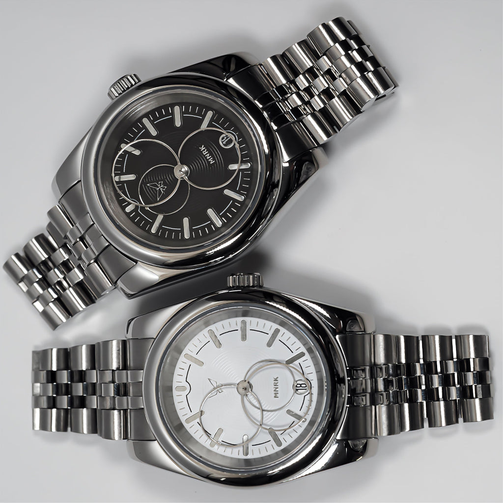 Two luxury silver watches with circular hands, one with a black dial and the other with a white one.