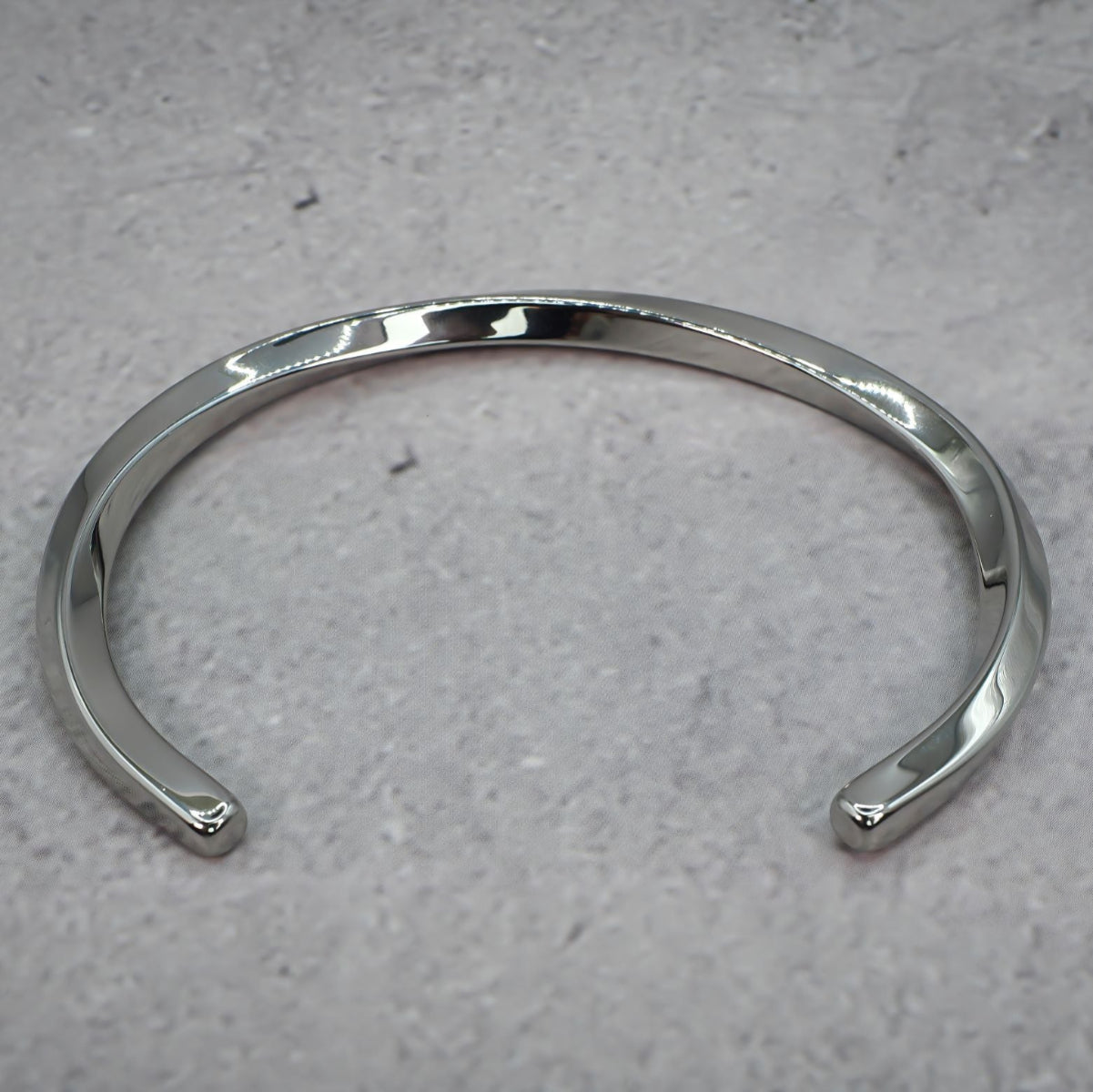 Silver metal bracelet on a grey counter.