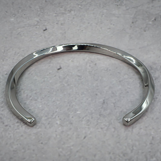 Silver metal bracelet on a grey counter.