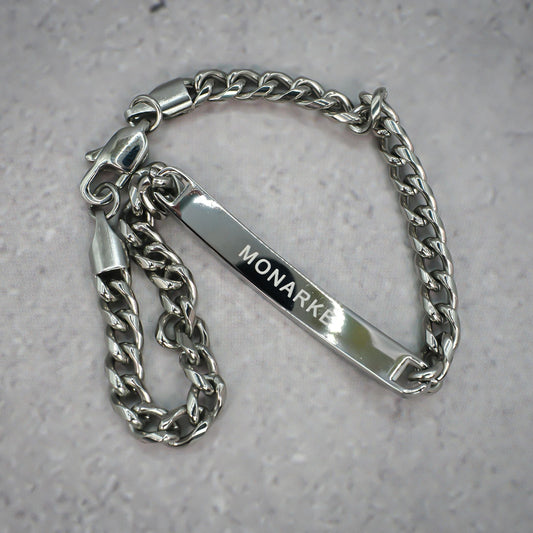 Silver chain bracelet with 'MONARKE' tag on a grey background.