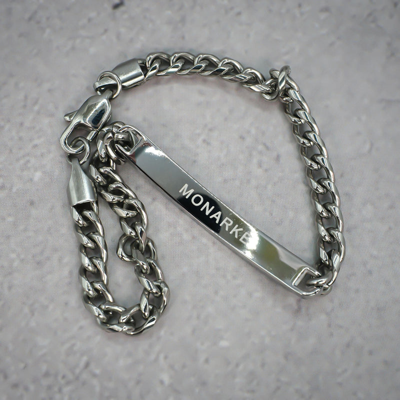 Silver chain bracelet with 'MONARKE' tag on a grey background.