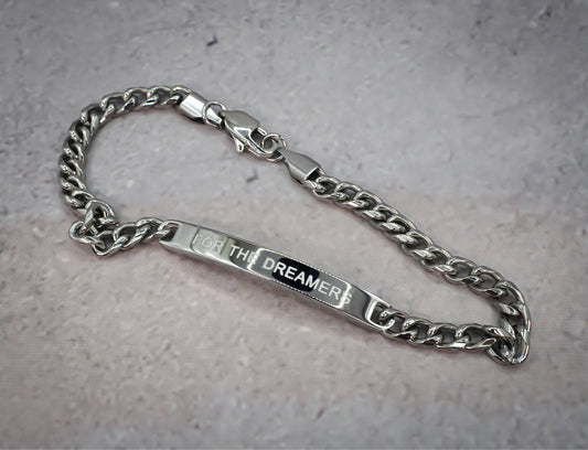 Silver chain bracelet underside with 'For the Dreamer' tag on a grey background