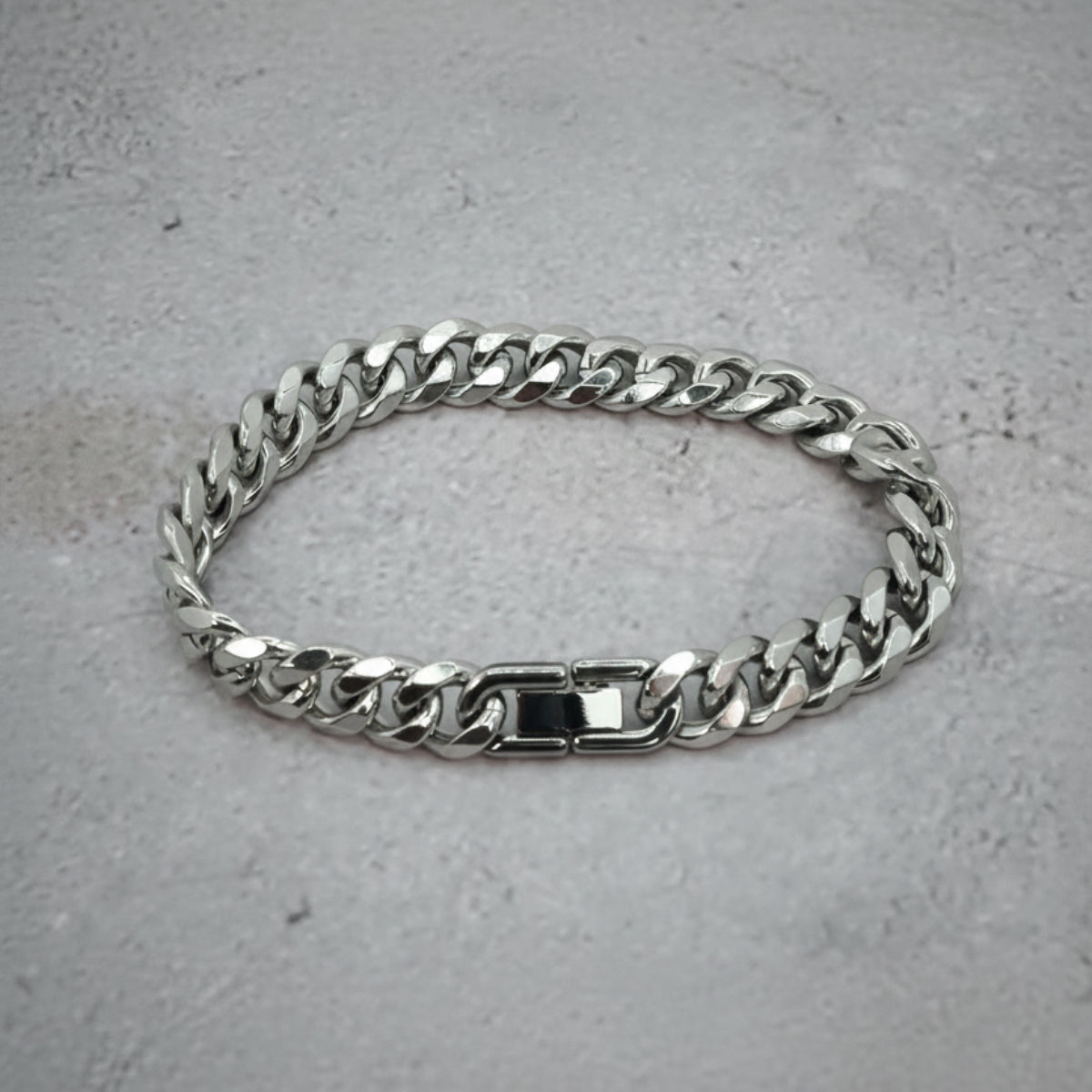 Top down view of a silver Cuban Bracelet on a grey counter.