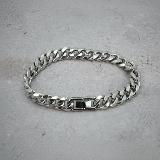 Top down view of a silver Cuban Bracelet on a grey counter.