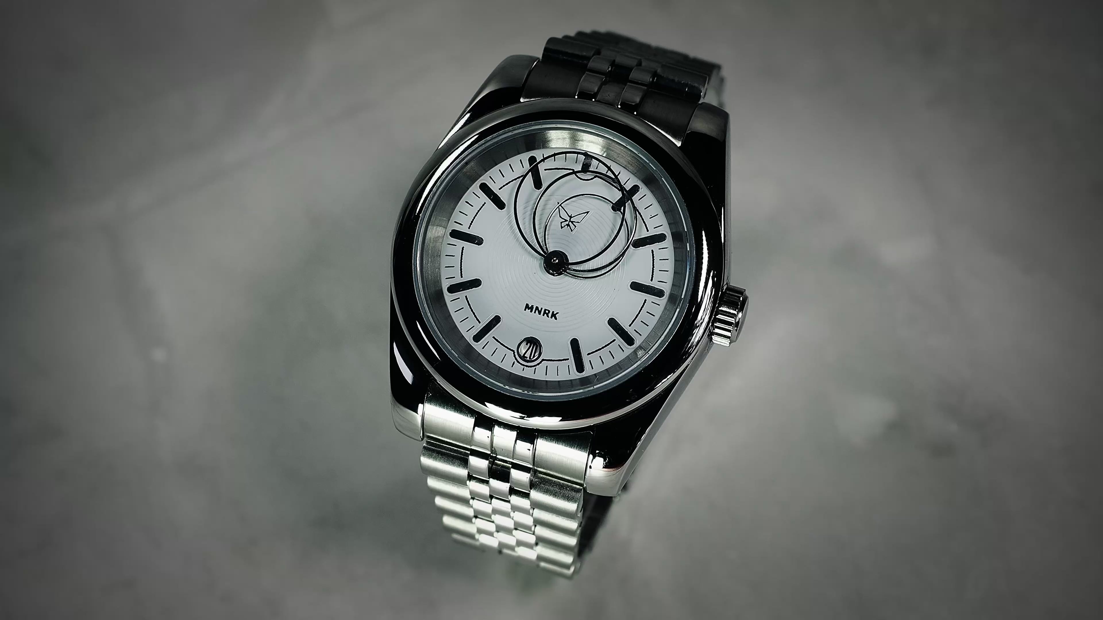 Luxury silver watch, with a white dial and circular hands, viewed from the front. The video shows the hands in motion
