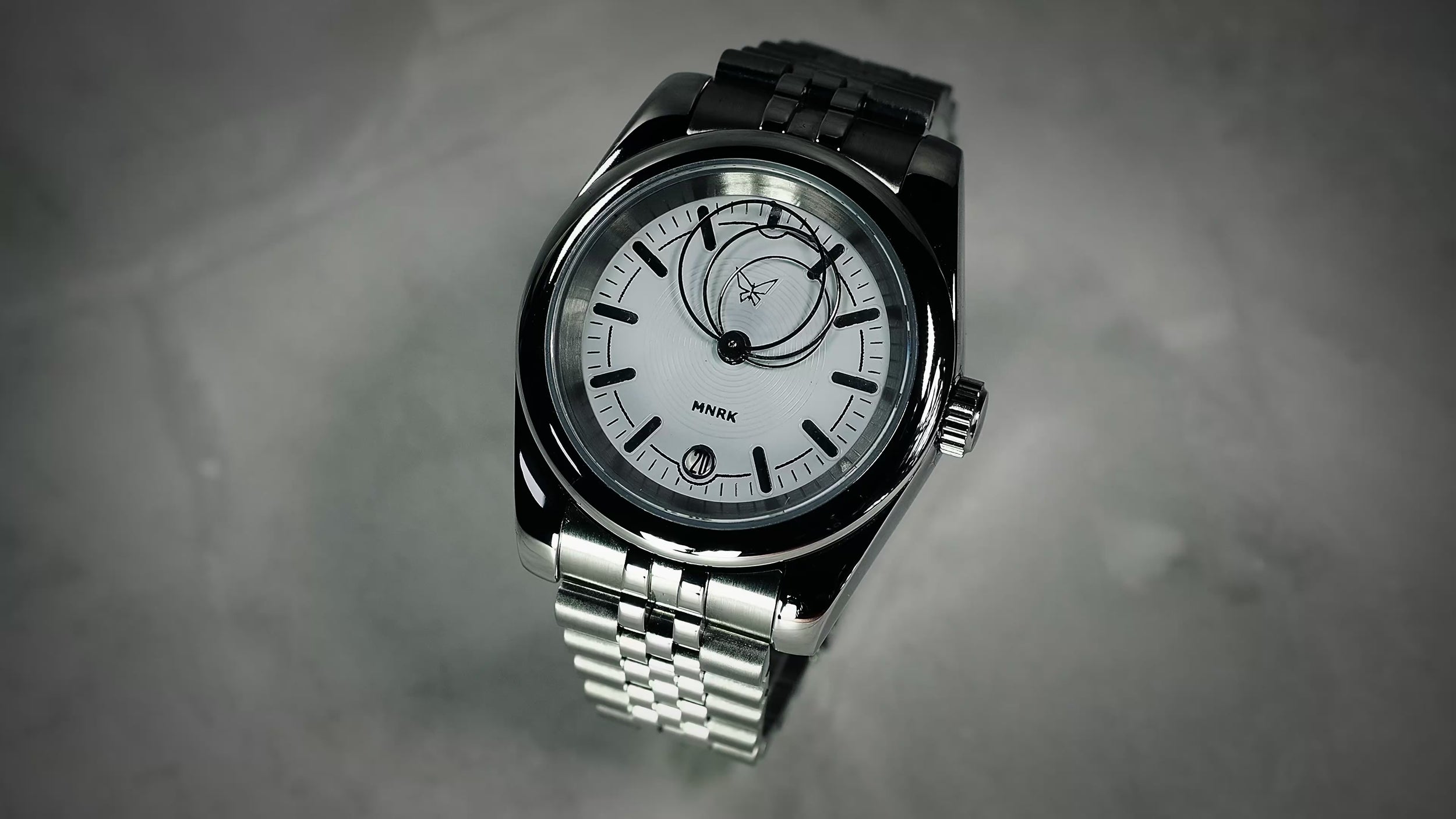 Luxury silver watch, with a white dial and circular hands, viewed from the front. The video shows the hands in motion
